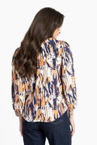 Woman wearing a patterned blouse with long hair on a white background