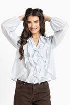 Woman wearing a white blouse with ruffles on a white background