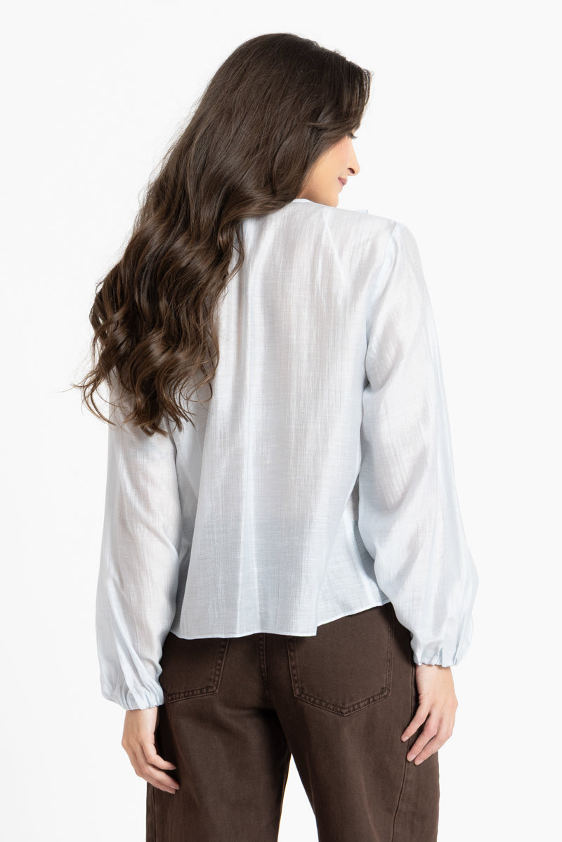 Woman wearing a white blouse and brown pants on a white background