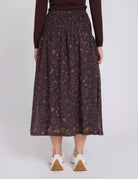 Person wearing a patterned skirt on a white background
