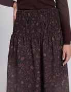 Brown floral-patterned skirt worn by a person on a white background
