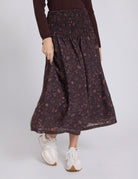 Person wearing a patterned skirt with a plain background