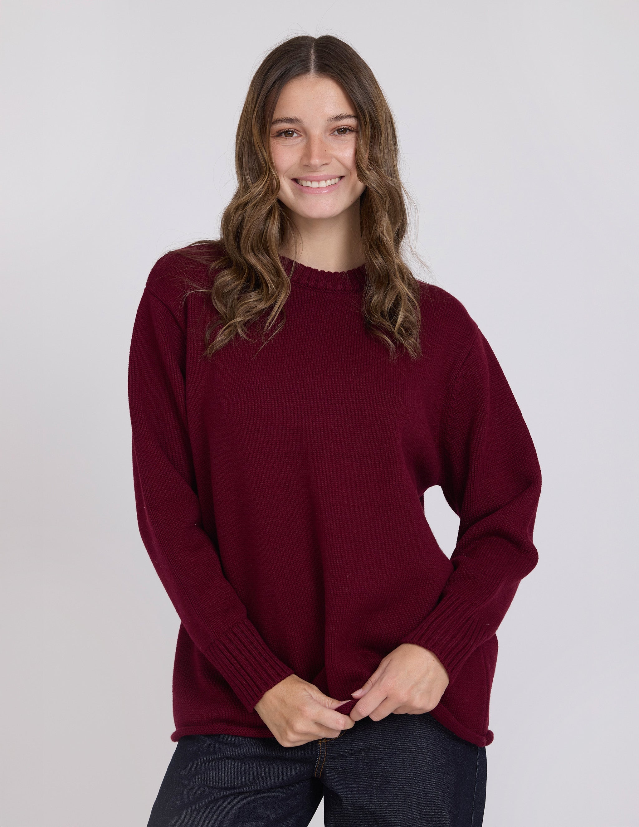 Woman wearing a burgundy sweater against a plain background