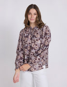 Woman wearing a floral blouse with long sleeves on a white background