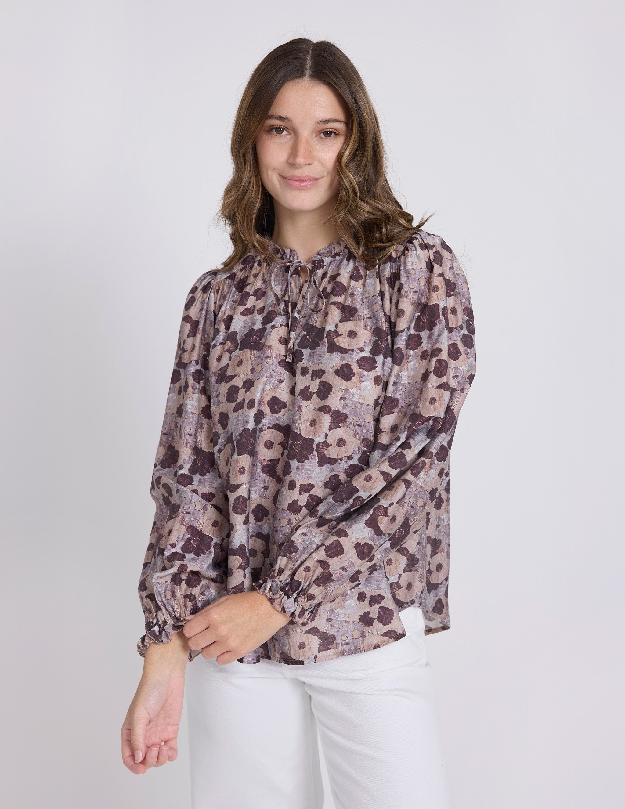 Woman wearing a floral blouse with long sleeves on a white background
