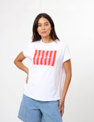 A women wearing a white short sleeve tee with a pink candy coloured print on the front