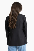 Person wearing a black blazer from behind on a white background