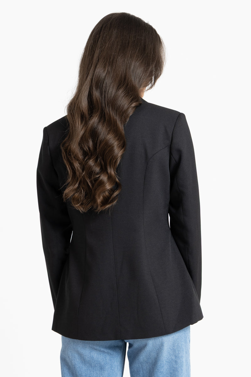 Person wearing a black blazer from behind on a white background