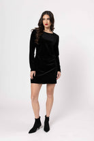 Woman wearing a black velvet dress on a white background