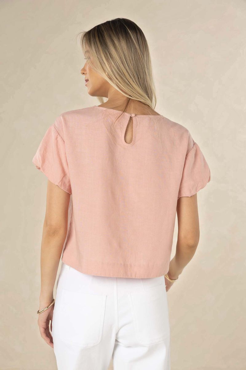 Woman wearing a pink blouse with a beige background