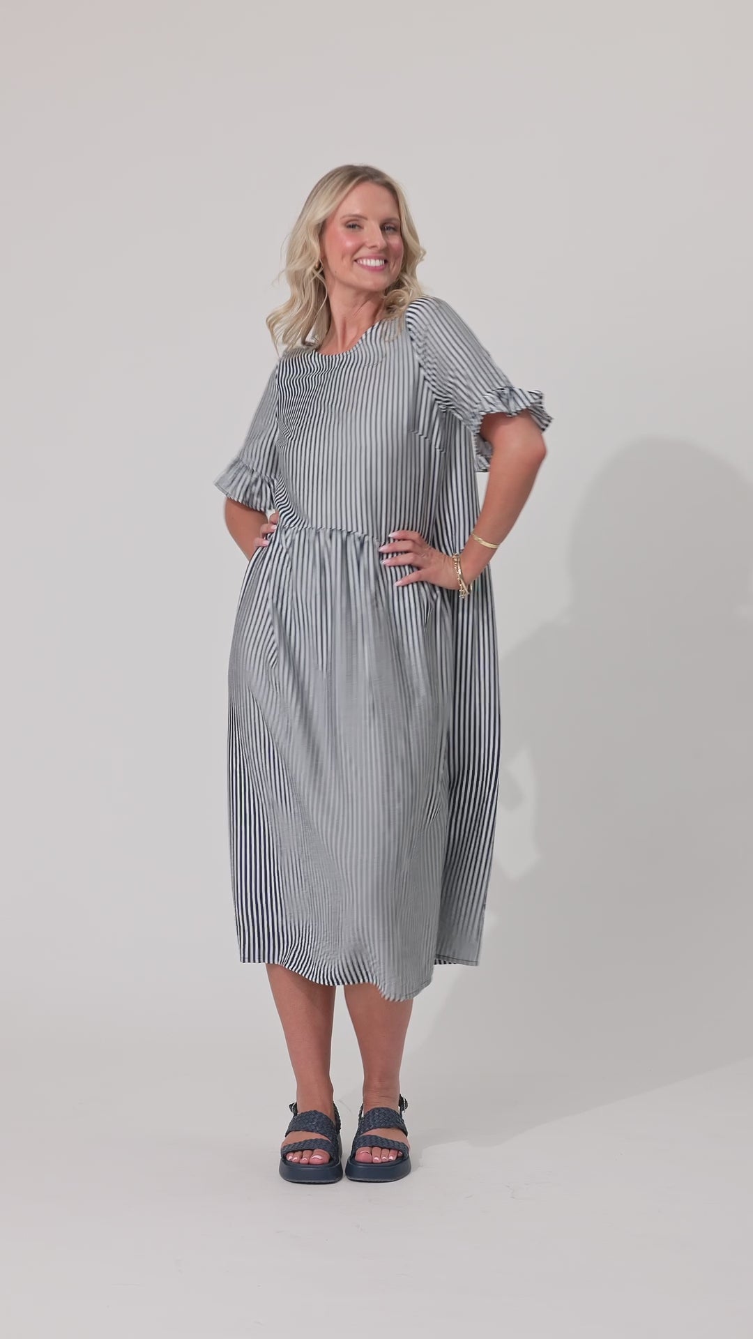 Video of a women in a long navy stripe dress
