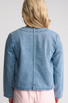 A child wearing a cropped light blue denim jacket, shown from the back against a light gray studio background.